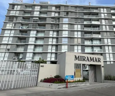 a large apartment building with a mimmar sign in front of it at Apartamento San Bartolo in San Bartolo