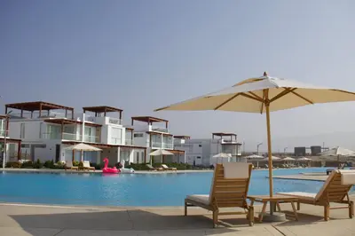 two chairs and an umbrella next to a swimming pool at Casa de Playa - Asia - SELENE beach house in Asia