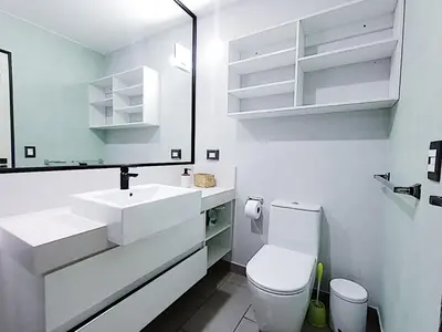 a white bathroom with a toilet and a sink at Apartment in San Isidro in Lima