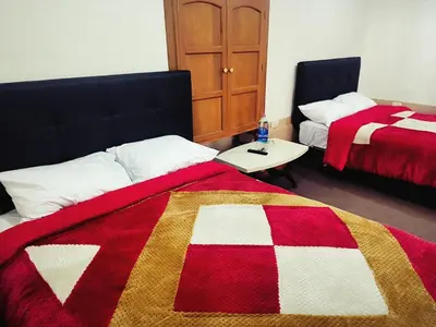 a bedroom with two beds with red and white blankets at Departamento 2 Waynapata Centro Historico Cusco in Cusco