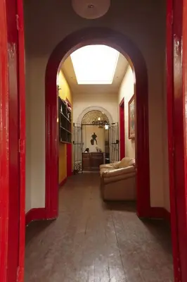a hallway with an archway with a couch in a room at Flying Dog Hostel in Lima