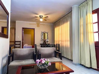 a living room with two chairs and a table at Apart-Hotel El Cañaveral in Chincha