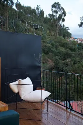 a white chair sitting on a balcony with a view at Casa Campestre on the side of Saqsaywaman in Cusco