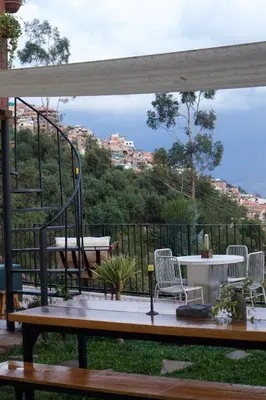 a patio with a table and chairs and a view at Casa Campestre on the side of Saqsaywaman in Cusco