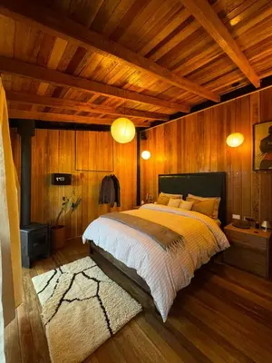 a bedroom with a large bed with wooden walls at Mountain lodge with Spectacular View in Cusco