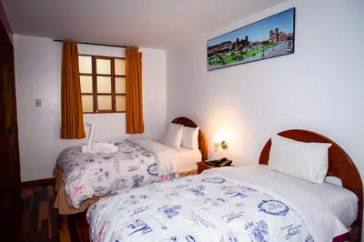 a hotel room with two beds and a window at Intitambo Hotel in Ollantaytambo