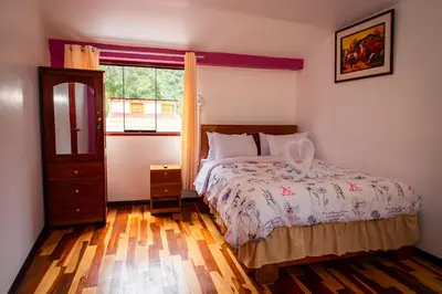 a bedroom with a bed and a window at Intitambo Hotel in Ollantaytambo