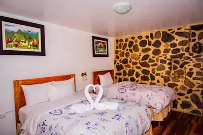 a hotel room with two beds with a swan on the bed at Intitambo Hotel in Ollantaytambo