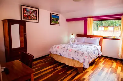 a bedroom with a bed and a window at Intitambo Hotel in Ollantaytambo