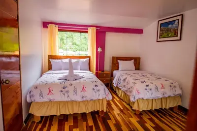 a bedroom with two beds and a window at Intitambo Hotel in Ollantaytambo