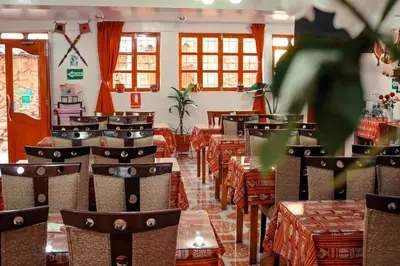 a restaurant with tables and chairs in a room at Intitambo Hotel in Ollantaytambo