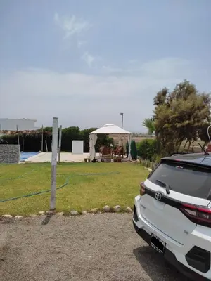 a white car parked next to a yard with a tent at Chinchacampoymar Casa de playa en Chincha in Chincha Baja