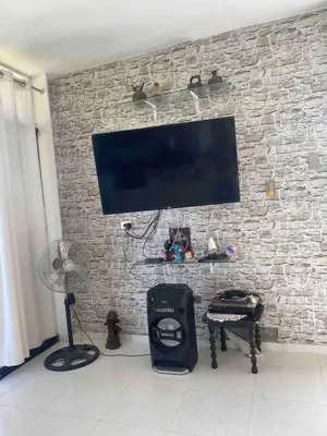 a flat screen tv hanging on a brick wall at Chinchacampoymar Casa de playa en Chincha in Chincha Baja