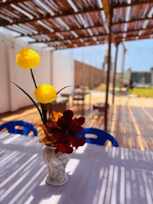 a vase with yellow and red flowers on a table at Casa Puente Azul - Casa de Playa in Cerro Azul