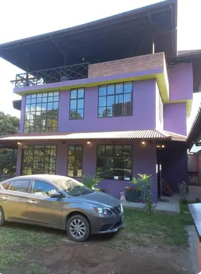 a car parked in front of a purple house at La Casa Morada in San Ramón