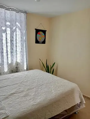 a bedroom with a bed and a clock on the wall at Alojamiento Casa en Ica in Ica