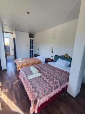 two beds in a hotel room with two towels on them at Casa Conquista in Cusco