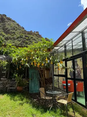 a patio with a table and chairs in front of a building at Anido Hotel in Ollantaytambo