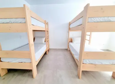 a room with three bunk beds in a hostel at Bujama beach Home Family Asia in Mala