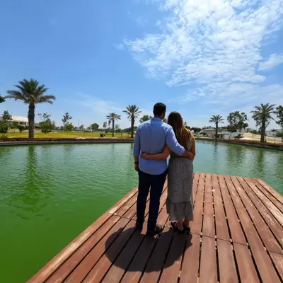 a man and woman standing on a wooden dock looking at the water at Bujama beach Home Family Asia in Mala