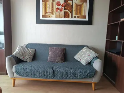 a couch with three pillows on it in a living room at Departamento con vista al Circuito Mágico del Agua in Lima