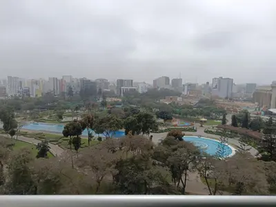 a view of a park with a city in the background at Departamento con vista al Circuito Mágico del Agua in Lima