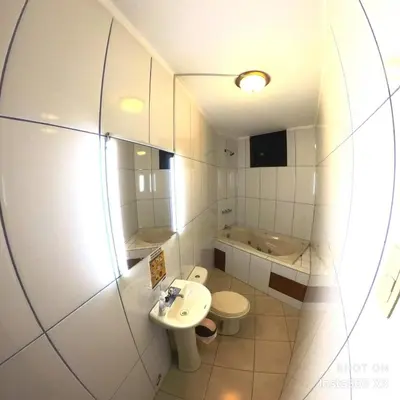 a bathroom with a sink and a toilet and a mirror at Hostal El Bosque in Huánuco