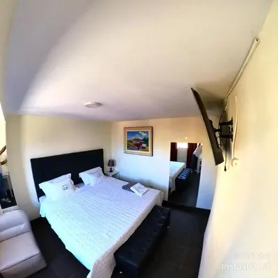 a hotel room with a bed and a couch at Hostal El Bosque in Huánuco