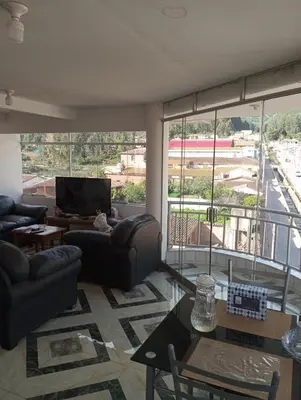 a living room with couches and a large window at Apartamento con vista espectacular al Valle Sagrado de los Incas in Urubamba