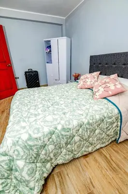a bedroom with a large bed with pink pillows at La covacha de viejo in Jauja