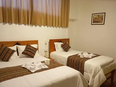 two beds sitting next to each other in a room at La casa de Goya in Cusco