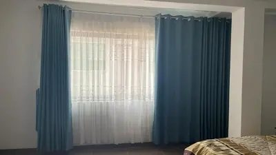a bedroom with a window with blue curtains at Malka Casas - Hoteles in Marco