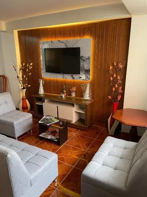 a living room with two couches and a flat screen tv at La esquina de vallecito in Cusco