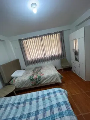 a bedroom with two beds and a window at La esquina de vallecito in Cusco