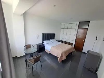 a bedroom with a bed and a table and chairs at Hotel Kendari - Chincha in Chincha