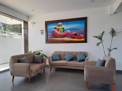 a living room with two couches and a painting on the wall at Hotel Kendari - Chincha in Chincha