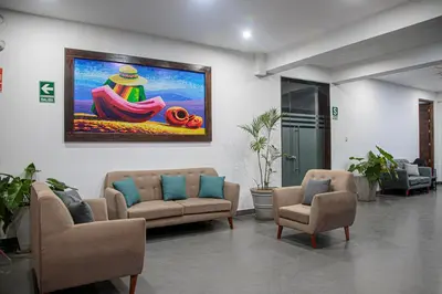 a waiting room with two chairs and a painting on the wall at Hotel Kendari - Chincha in Chincha