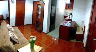 a kitchen and living room with a couch and a table at La Palmera in Lima