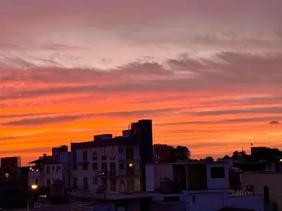 a sunset over a city with a building at La Palmera in Lima