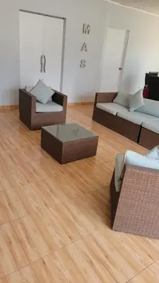 a living room with three beds and a wooden floor at Villa MAS - Condominio Hacienda II in Pachacamac