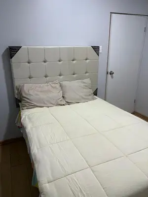 a large white bed with a white padded headboard at Villa MAS - Condominio Hacienda II in Pachacamac