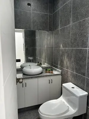 a bathroom with a white toilet and a sink at Linda Casa en Condominio in Asia