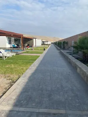 a long walkway leading to a building with a brick wall at Linda Casa en Condominio in Asia