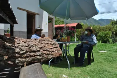 three people sitting at a table under an umbrella at Pisonaywasi - Hospedaje familiar in Urubamba
