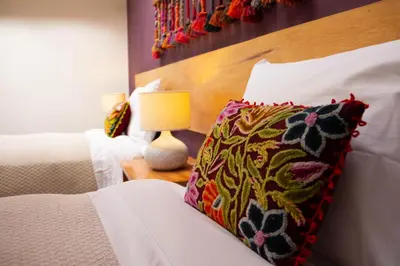 a bedroom with a bed with a pillow and a lamp at Casa de La Chola in Ollantaytambo