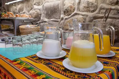 a table topped with glasses of milk and juice at La Casona Real Cusco in Cusco