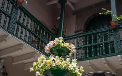 a vase with flowers hanging from a staircase at La Casona Real Cusco in Cusco