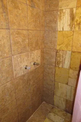 a bathroom with a shower with a tiled shower at Hospedaje Kamila in Cusco