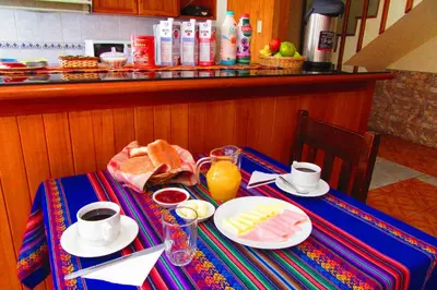 a table with breakfast foods and drinks on it at Hospedaje Kamila in Cusco