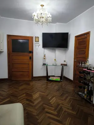 a living room with a television and a wooden floor at Lindo apartmento en PLAZA PRINCIPAL in Lima
